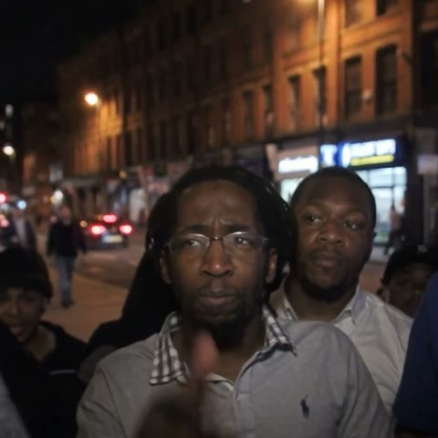 The crowd — Night on the street, a crowd packed in under the lights. Someone's filming.